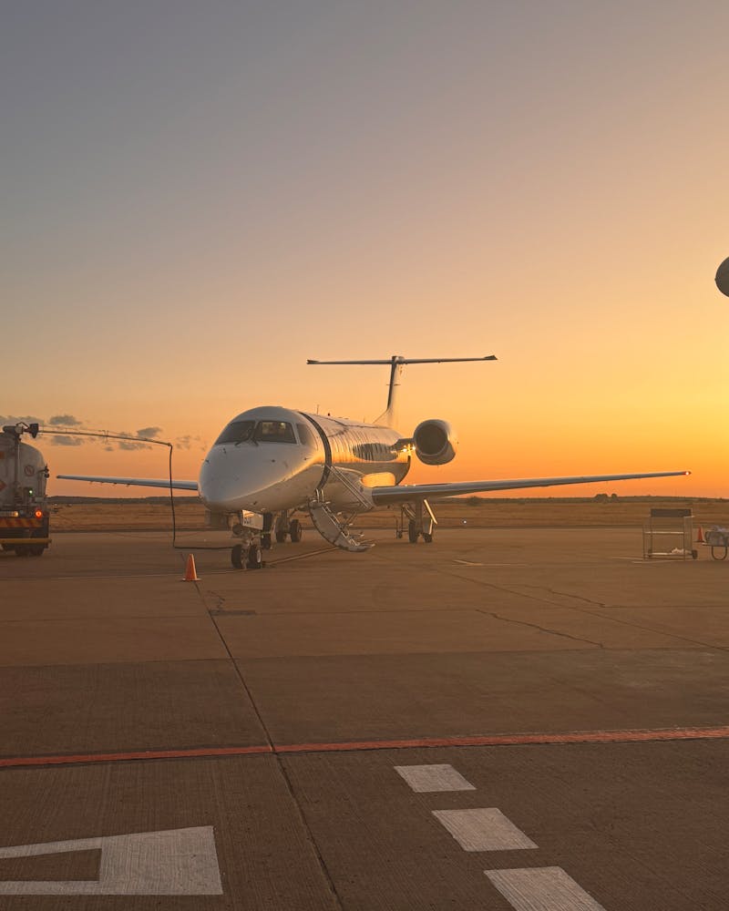 Private jet on tarmac at sunset